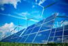 A picture of solar panels and wind turbines in a field.