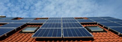 Solar panels on a rooftop and blue skies.