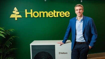 Simon Phelan of Hometree stands beside a heat pump.