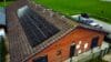 View of building from above with solar panels embedded in the roof.