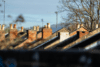 Rooftops of UK houses and blue sky.