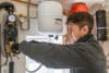 An installer is pictured installing a heat pump.