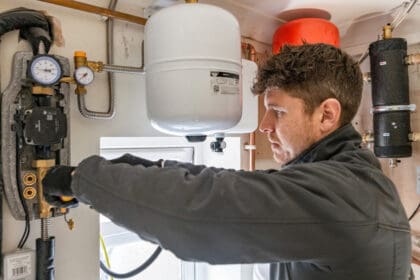 An installer is pictured installing a heat pump.