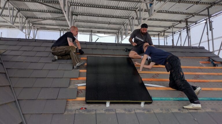 Viridian solar panels being installed on the roof of a house.