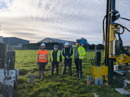 Team lined up beneath building equipment