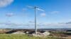 Photograph of one small G-11 wind turbine in a field.