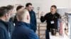 A group of installers gathered around in a training environment.