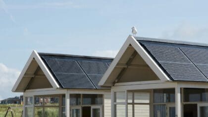 A picture of two domestic roofs with solar panels on them.